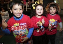 Wiggles fans from left, Adam, Alexia and Jonathan dance during a public appearance of the group at a outer city shopping center in Sydney, Australia